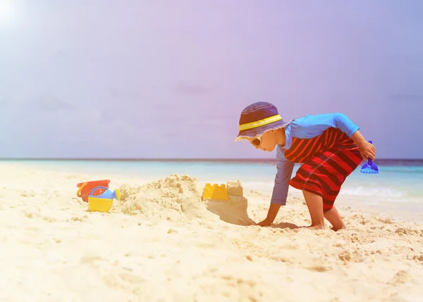 Menino construção sandcastle na praia tropical — Fotografia de Stock