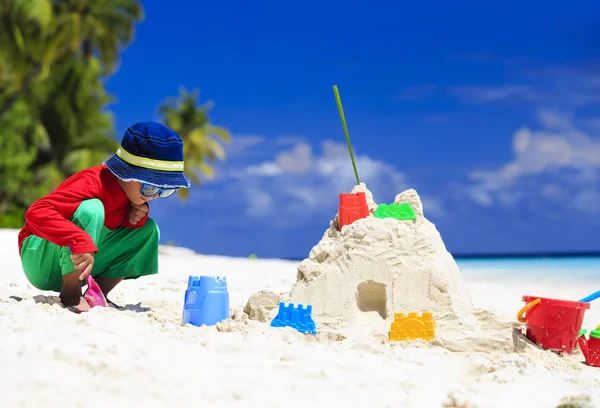 Épület homokvár trópusi tengerparton kisfiú — Stock Fotó