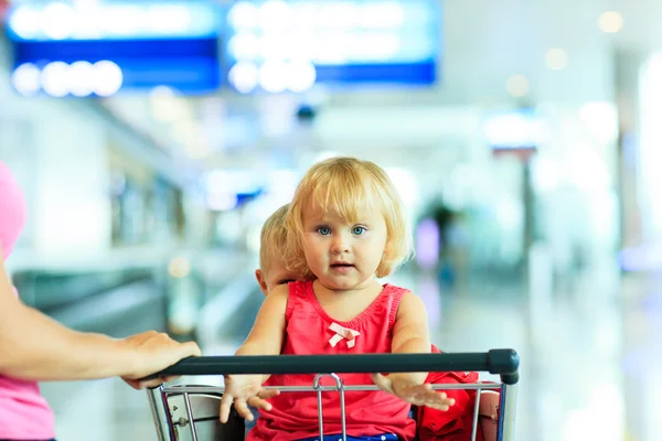 Mor och barn på bagage vagn på flygplatsen — Stockfoto