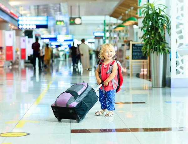Liten flicka med resväska resor på flygplatsen — Stockfoto