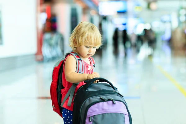 Liten flicka med resväska resor på flygplatsen — Stockfoto