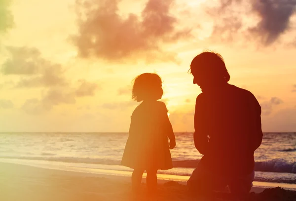 Silhouettes père et petite fille au coucher du soleil — Photo