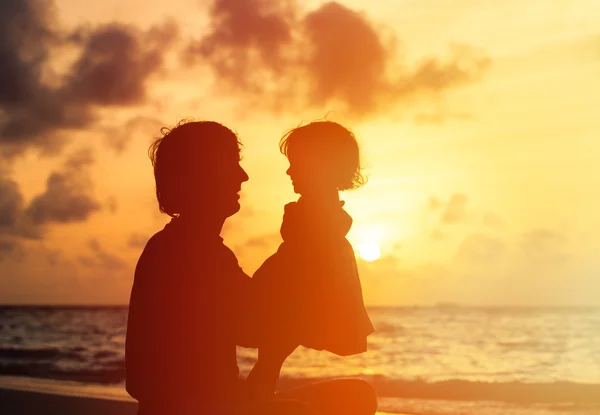 Silhouettes père et petite fille au coucher du soleil — Photo