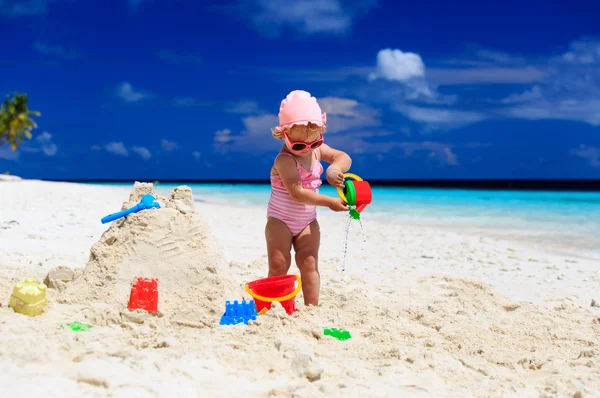 Carina bambina che gioca con la sabbia sulla spiaggia — Foto Stock