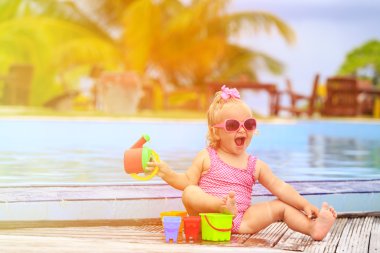 sevimli kız plajda yüzme havuzunda oynayan