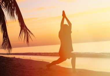 Gün batımında meditasyon genç adam silüeti