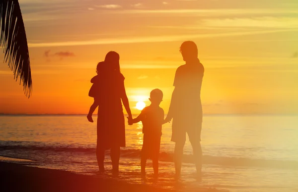 Glückliche Familie mit zwei Kindern am Strand bei Sonnenuntergang — Stockfoto