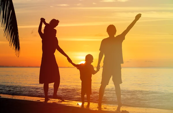 Famille heureuse avec deux enfants s'amusant au coucher du soleil — Photo