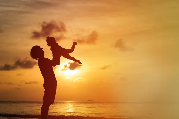 Siluetas de padre e hija pequeña al atardecer —  Fotos de Stock