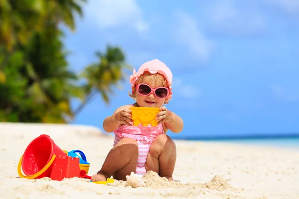 Roztomilá holčička, hraní s pískem na pláži — Stock fotografie