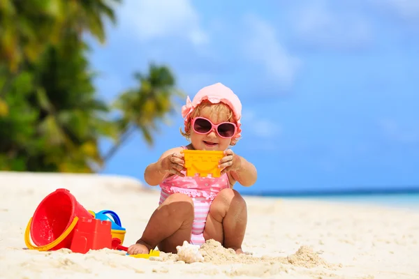 Cute dziewczynka gra z piasku na plaży — Zdjęcie stockowe