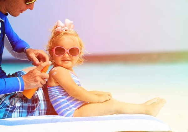 Père appliquant crème solaire sur les filles épaule — Photo