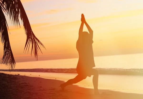 Silhueta de jovem meditando ao pôr do sol — Fotografia de Stock