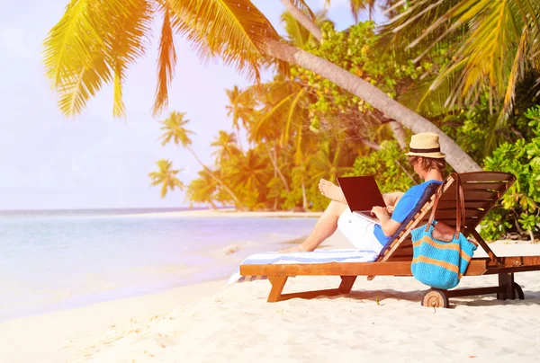 Mann mit Laptop am tropischen Strand — Stockfoto