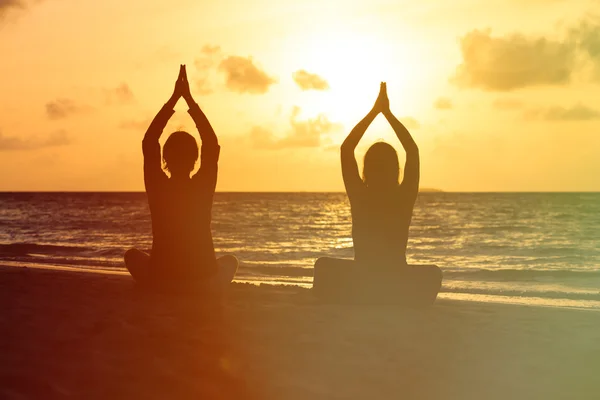 Silhouet van het paar doen yoga bij zonsondergang — Stockfoto