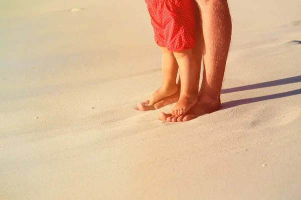 Primer plano de padre e hija pequeña pies en la playa — Foto de Stock