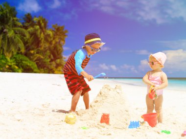 Sandcastle plajda bina küçük çocuk ve yürümeye başlayan çocuk kız