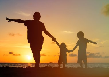 father with kids silhouettes having fun at sunset clipart