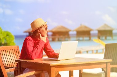 Lüks beach Resort dizüstü bilgisayar ile genç adam