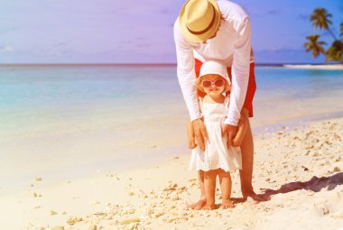 Baba ve küçük kız yaz sahilde yürüyüş