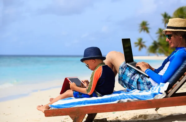 Familj med laptop och touch pad på stranden — Stockfoto