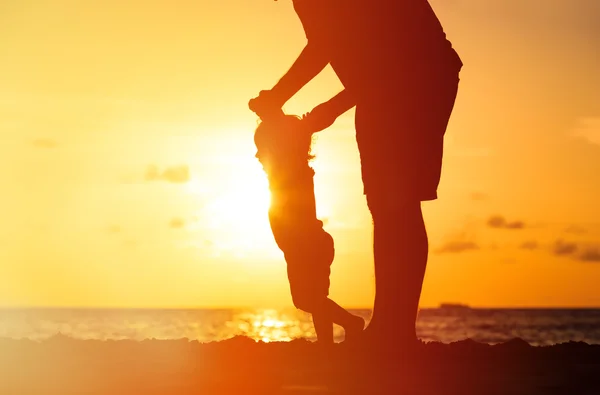 父亲和小女儿散步在日落时的剪影 — 图库照片