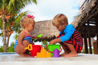 Yüzme havuzunda oynayan küçük çocuk ve yürümeye başlayan çocuk kız
