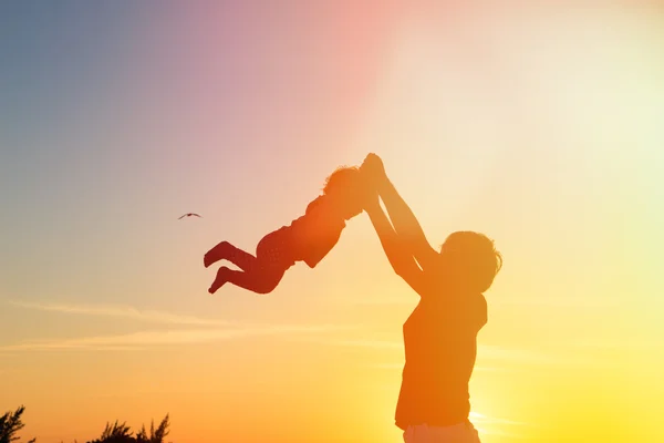 Vater und kleine Tochter spielen bei Sonnenuntergang — Stockfoto