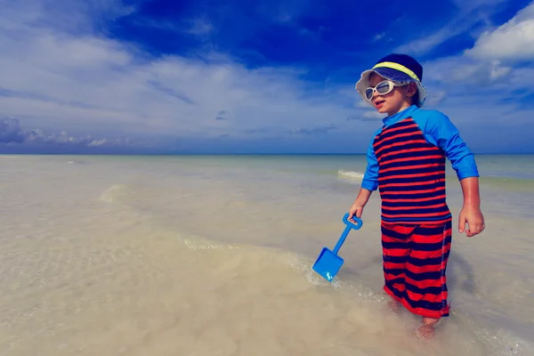 Kleine jongen spelen met water op zomer strand — Stockfoto