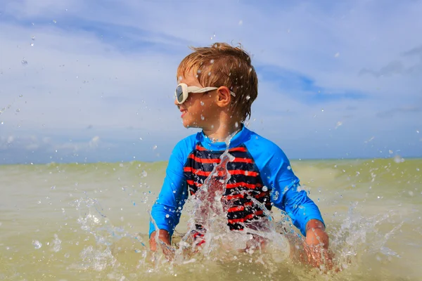 Little boy playing with water on tropical beach — Stock Photo, Image