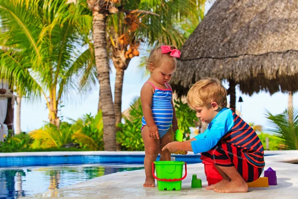 Petit garçon et tout-petit fille jouer dans la piscine — Photo