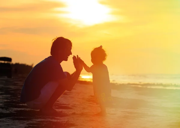 Ojciec i trochę sylwetki córka o zachodzie słońca — Zdjęcie stockowe