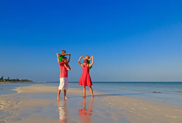 Семья с двумя детьми развлекается на песчаном пляже — стоковое фото