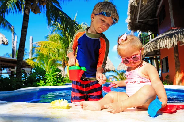 Malý chlapec a batole dívka si hraje v bazénu — Stock fotografie