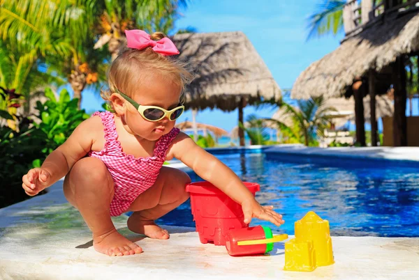 Malá holčička v bazénu na tropické pláži — Stock fotografie