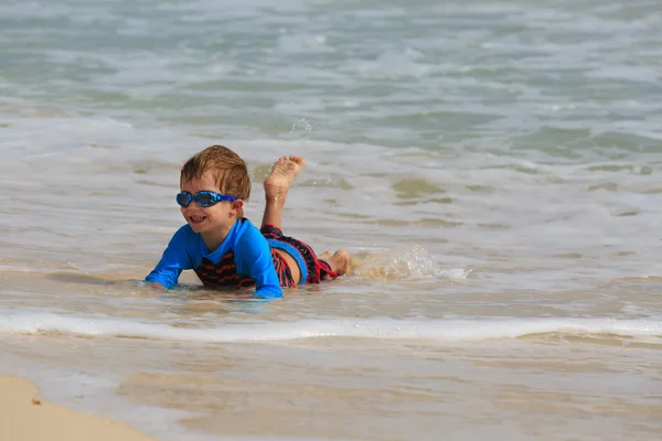 Mały chłopiec bawi się fale na plaży — Zdjęcie stockowe