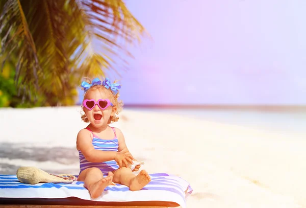 Cute little girl with seashells on summer beach — Stock Photo, Image