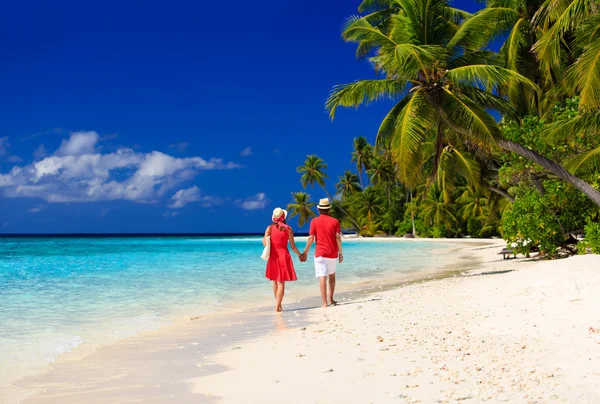 Lyckliga älskande paret gå på tropical beach — Stockfoto