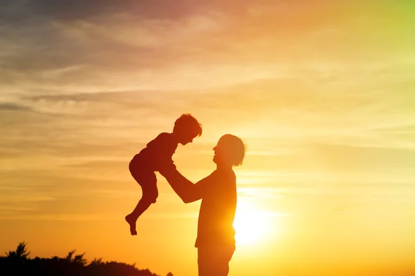 Pai e filho brincam ao pôr do sol — Fotografia de Stock