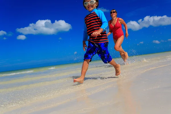 Little boy and mother running on beach — Stock Photo, Image