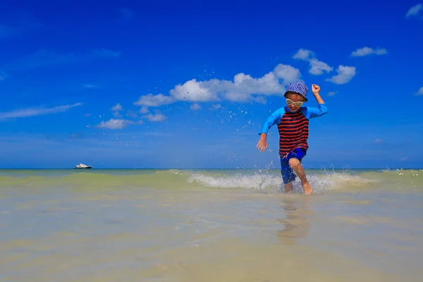 Little boy playing with water on summer beach — Stock Photo, Image