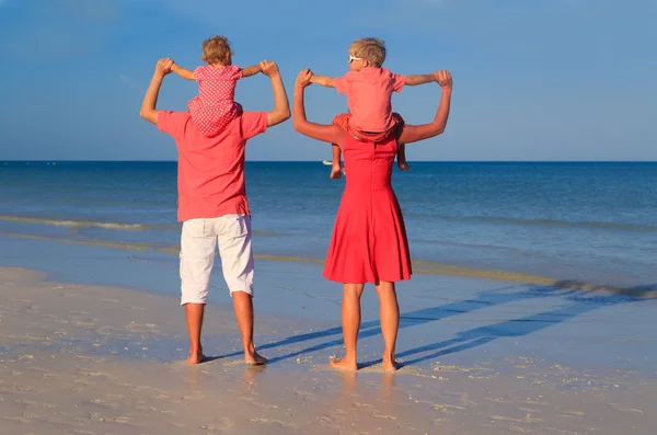 Achteraanzicht van gezin met twee kinderen plezier op het strand — Stockfoto