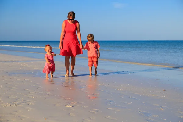 Madre y dos niños caminando en la playa — Foto de Stock