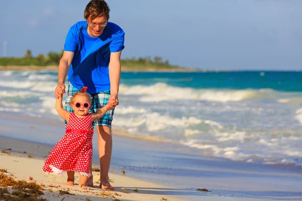 Vader en dochtertje wandelen op het strand — Stockfoto