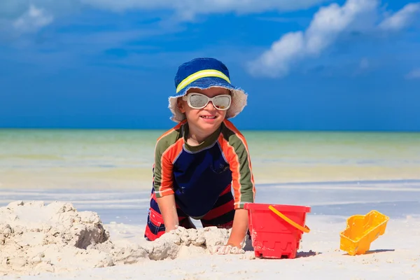 Mały chłopiec kopanie piasku na tropikalnej plaży — Zdjęcie stockowe