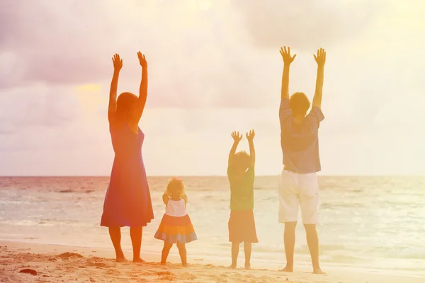 Famille heureuse avec deux enfants s'amusant au coucher du soleil — Photo