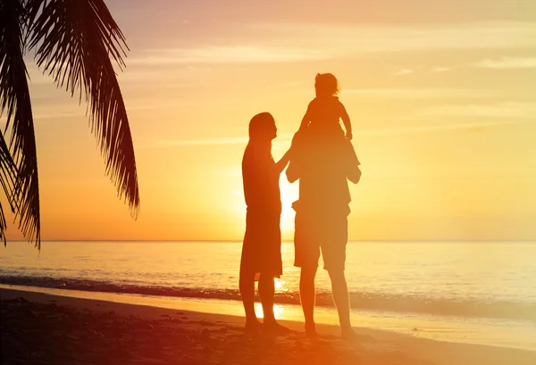 Couple romantique avec petit enfant à la plage du coucher du soleil — Photo