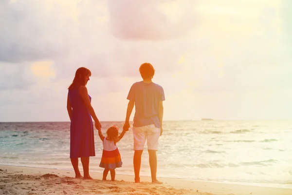 Šťastná rodina pohromadě na pláži při západu slunce — Stock fotografie