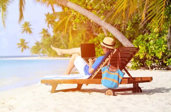 Mann mit Laptop im Urlaub am Tropenstrand — Stockfoto