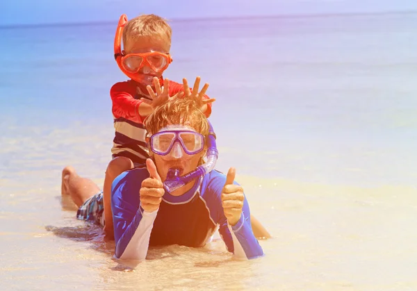 Feliz padre e hijo haciendo snorkel en la playa tropical — Foto de Stock